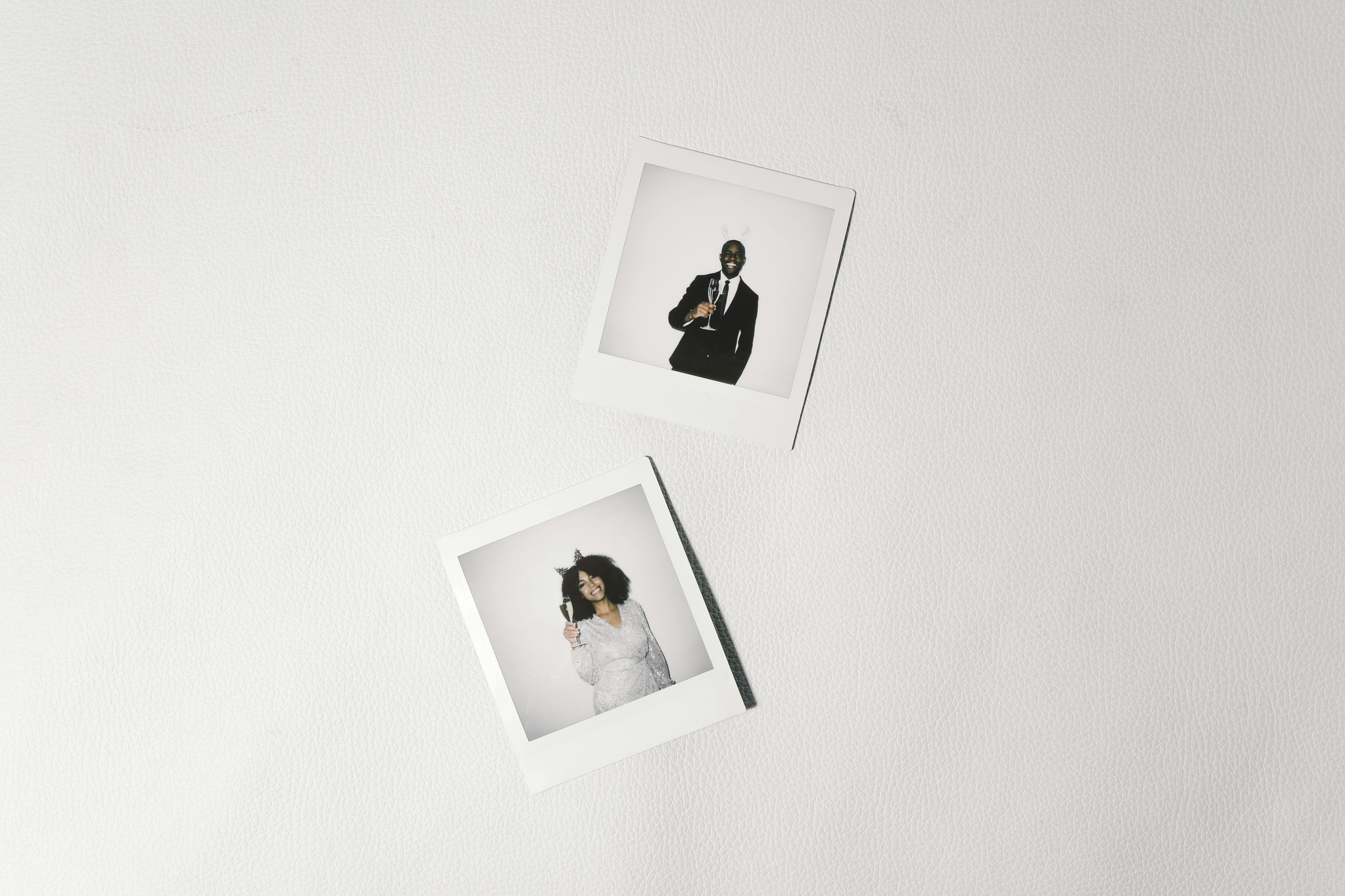 Two Polaroid photos on a white background with people dressed for an event, providing copy space.